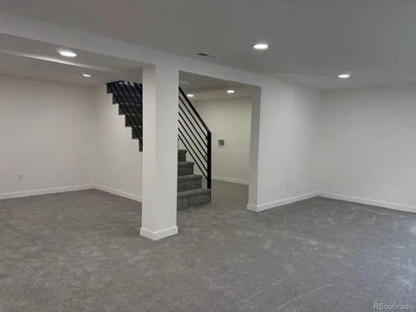 an empty room with a ceiling fan and stairs