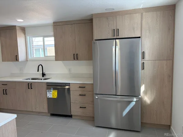 a kitchen with stainless steel appliances granite countertop a refrigerator and a sink