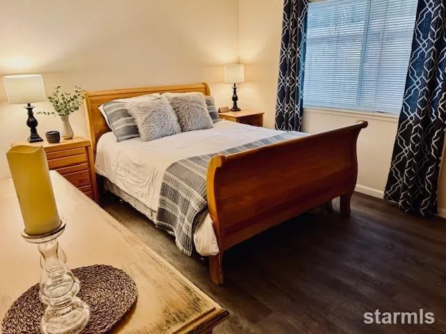 a bed sitting in a bedroom next to a window and potted plants