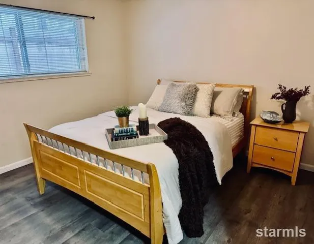 a bedroom with a bed and wooden floor