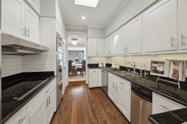 a kitchen with granite countertop stainless steel appliances and white cabinets
