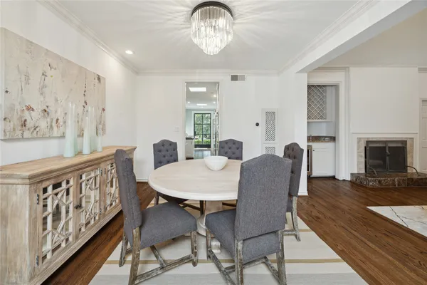 a view of a dining room with furniture a chandelier and wooden floor