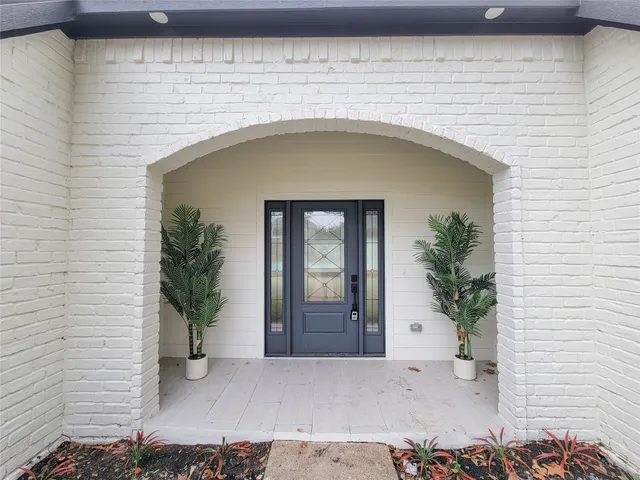 a front view of a house with potted plants