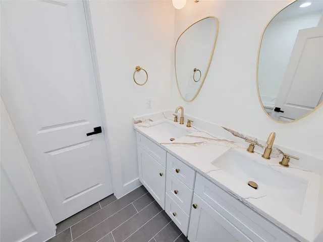 a bathroom with a double vanity sink and mirror