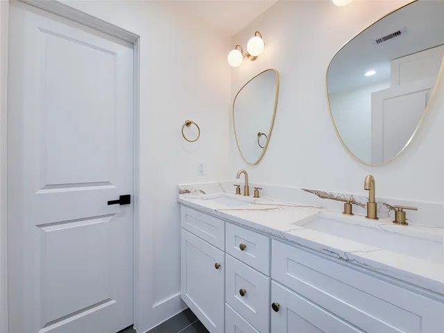 a bathroom with a double vanity sink and a mirror