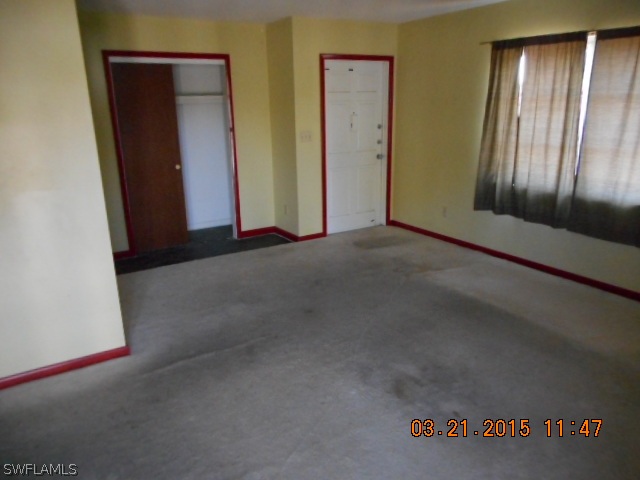 107 Davis Road Lehigh Acres, FL 33936 - Photo 4 of 9 an empty room with closet and wooden floor