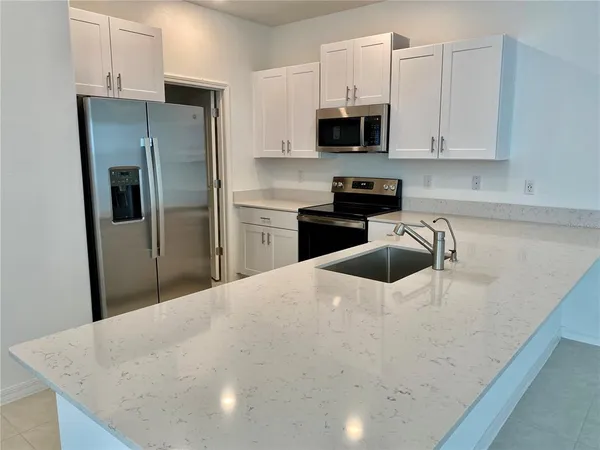 a kitchen with stainless steel appliances a refrigerator stove microwave and sink