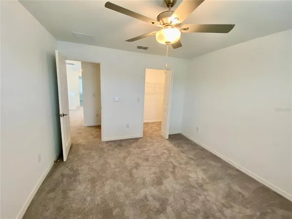 an empty room with a ceiling fan and a window