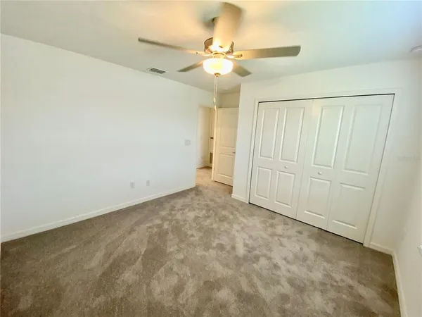 an empty room with a ceiling fan and a window
