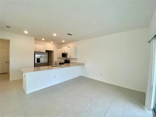 a view of kitchen with stainless steel appliances refrigerator sink and cabinets