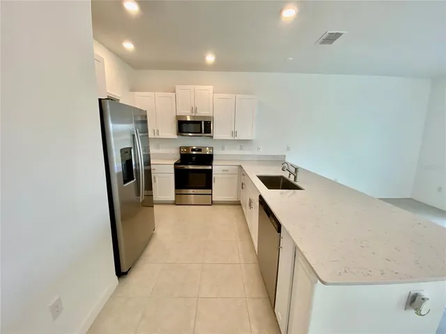 a kitchen with refrigerator a stove and cabinets
