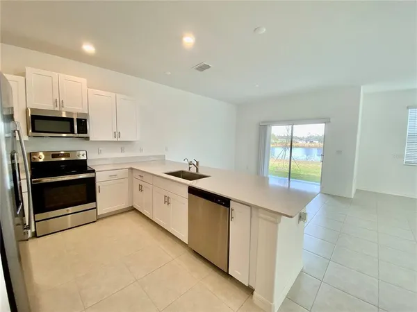 a kitchen with stainless steel appliances a stove a sink a microwave and cabinets