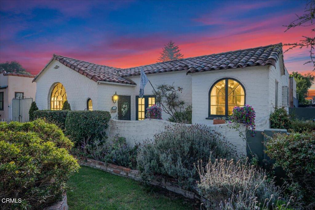 a view of a house with large trees and a yard