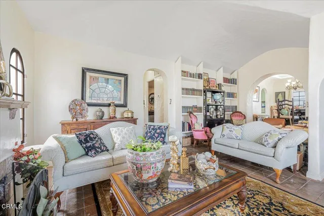 a living room with fireplace furniture and a large window