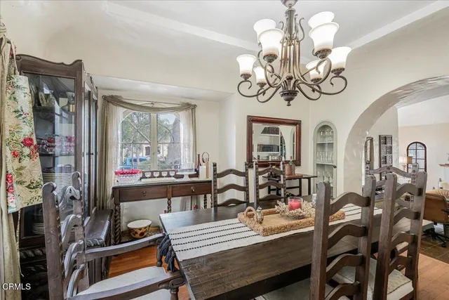 a view of a dining room with furniture a chandelier and wooden floor