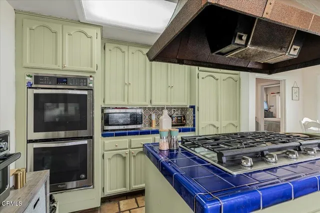 a kitchen with stainless steel appliances granite countertop a refrigerator and a wooden cabinets