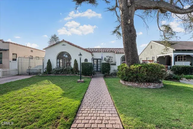 a front view of a house with outdoor seating and a potted plant