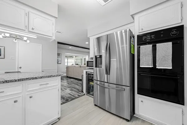 a kitchen with granite countertop stainless steel appliances a refrigerator a stove and cabinets