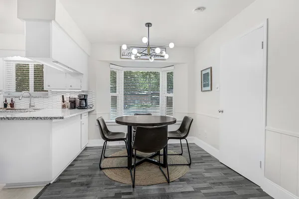 a dining room with furniture a chandelier and wooden floor