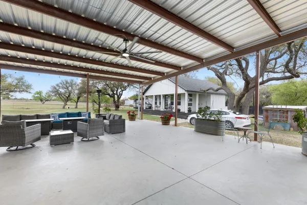 a front view of a house with swimming pool table and chairs