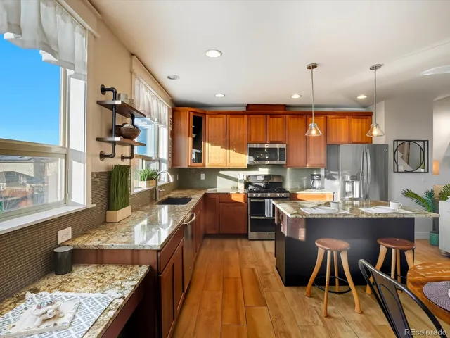 a kitchen with stainless steel appliances granite countertop sink stove top oven and cabinets