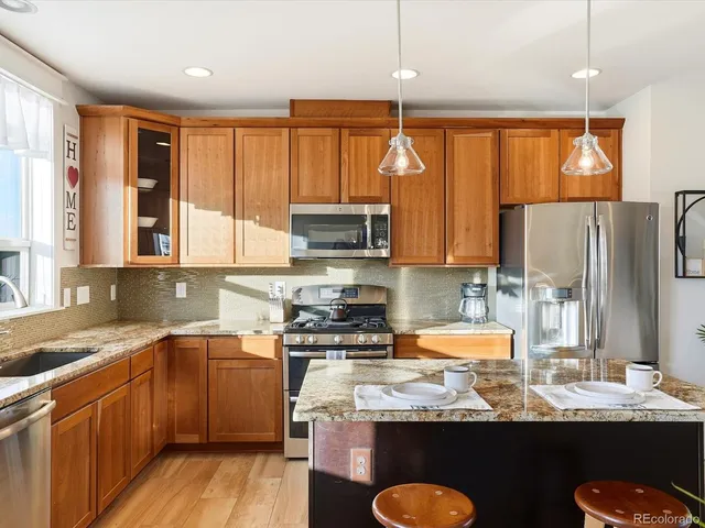 a kitchen with stainless steel appliances granite countertop a sink stove and refrigerator