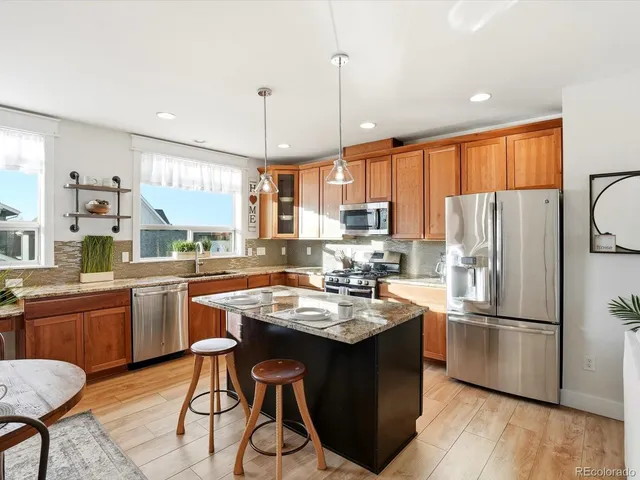 a kitchen with refrigerator a sink and chairs