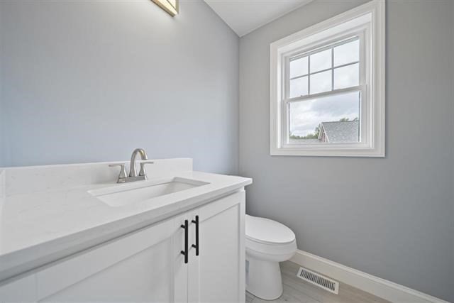 7 Bartons Rdg Road, Unit 7 Greenville, NH 03048 - Photo 12 of 28 a bathroom with a granite countertop toilet a sink and a window