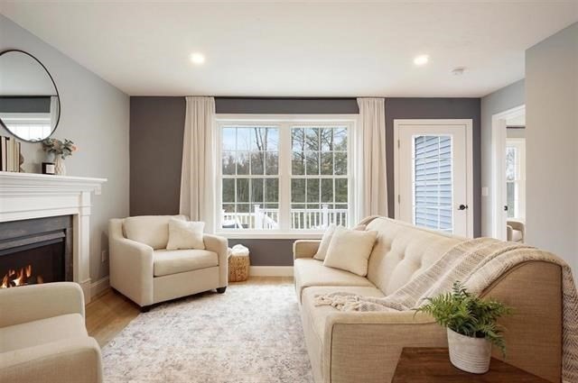 7 Bartons Rdg Road, Unit 7 Greenville, NH 03048 - Photo 2 of 28 a living room with furniture a fireplace and a large mirror