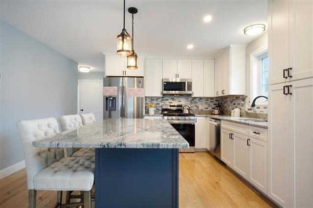 7 Bartons Rdg Road, Unit 7 Greenville, NH 03048 - Photo 4 of 28 a kitchen with kitchen island granite countertop a sink appliances cabinets and counter space