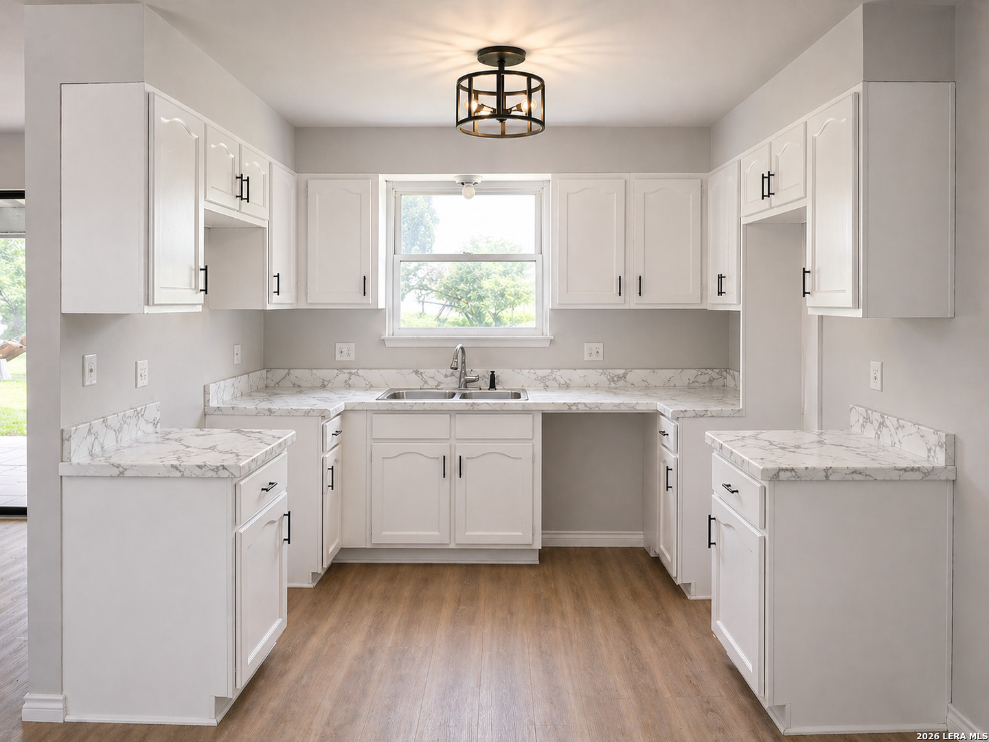 302 Booster Street Center Point, TX 78010 - Photo 4 of 6 a kitchen with granite countertop white cabinets white appliances a sink and dishwasher with wooden floor
