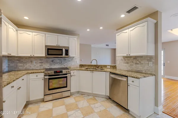 a kitchen with stainless steel appliances granite countertop a stove top oven a sink and a granite counter tops