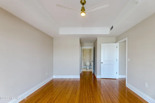 a view of empty room with wooden floor