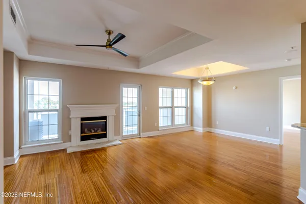a view of empty room with wooden floor and fireplace