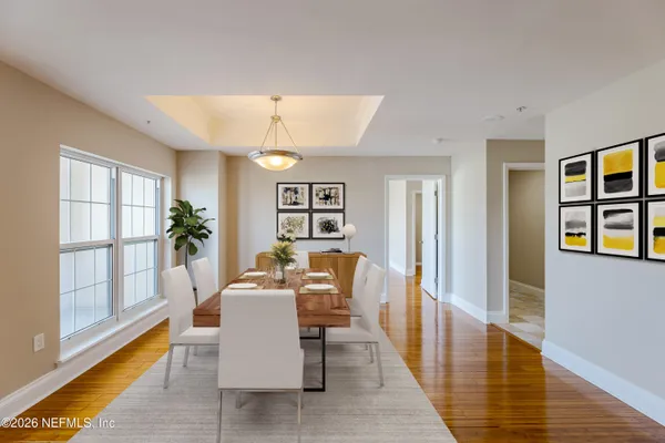 a dining room with wooden floor and large window