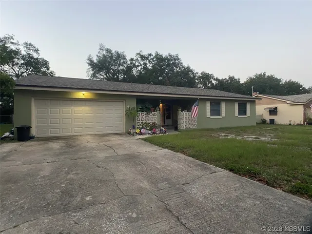 a front view of house with yard and trees in the background