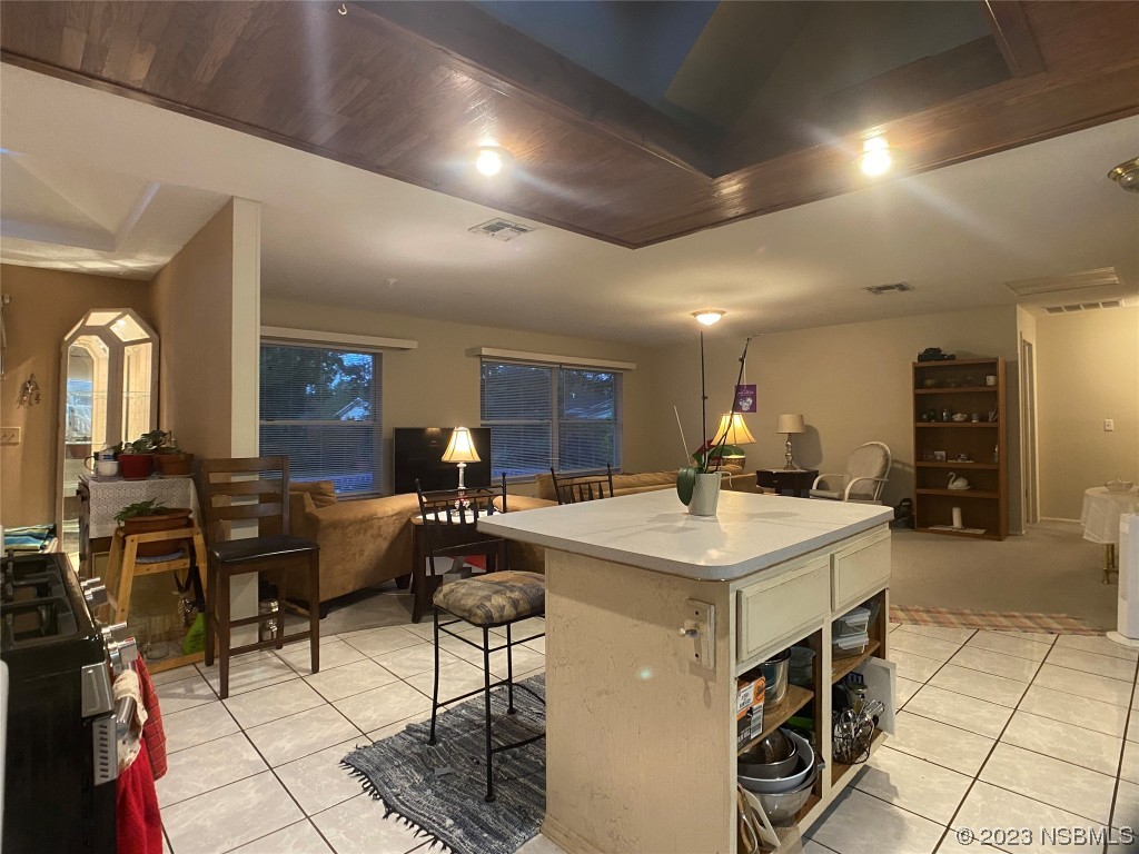Undisclosed Address Casselberry, FL 32707 - Photo 11 of 19 a view of a kitchen with kitchen island a stove a refrigerator a dining table and chairs with wooden floor