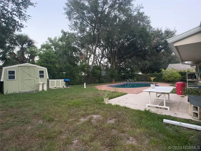 a view of a house with backyard and sitting area