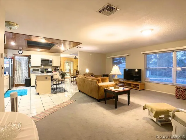 a living room with furniture kitchen view and a table