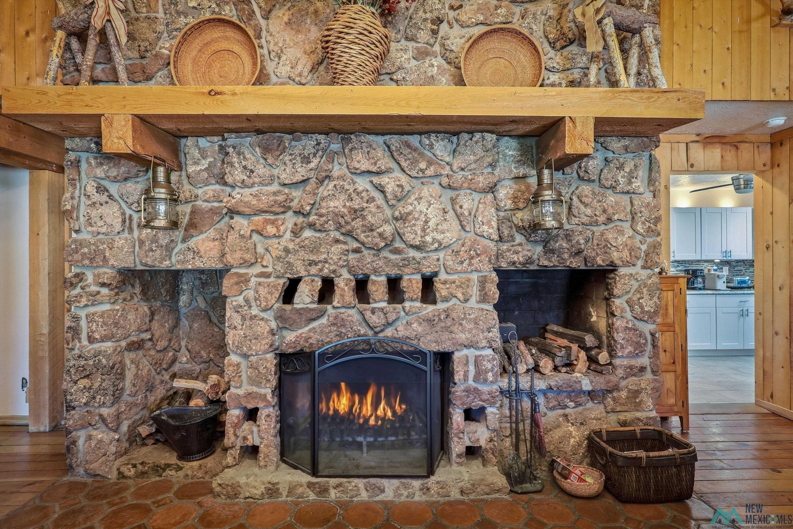 83 Juniper Road Chama, NM 87520 - Photo 7 of 56 Stone fireplace featuring a natural wood mantel and hearth