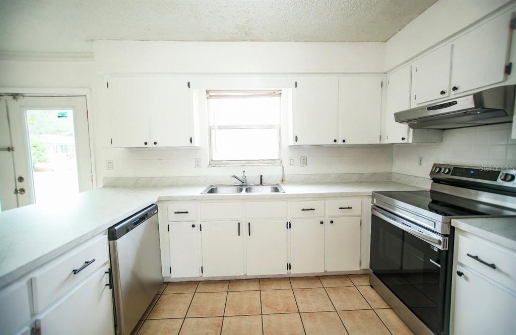 606 Water Road Ocala, FL 34472 - Photo 13 of 34 a kitchen with cabinets appliances a sink and a window
