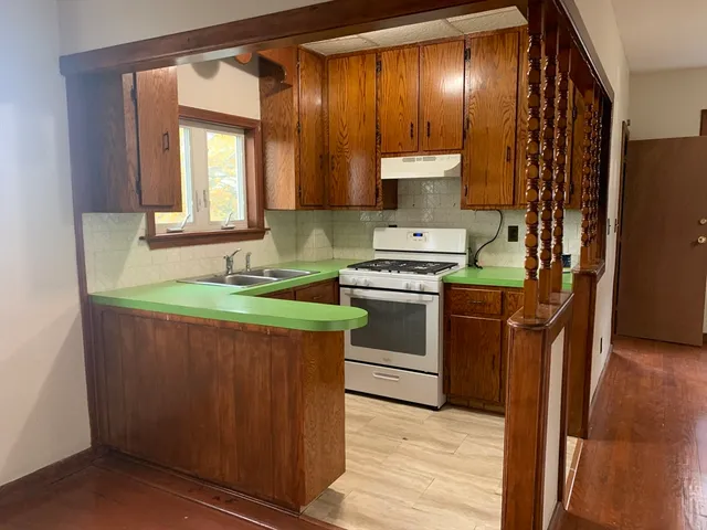a kitchen with stainless steel appliances a sink stove and cabinets