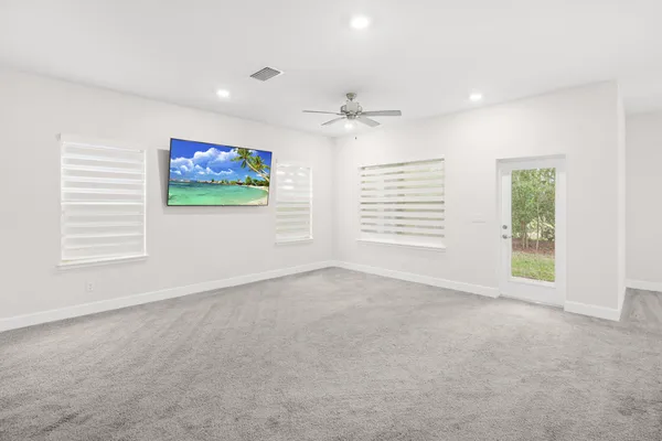 a spacious bedroom with a bed and a ceiling fan in it
