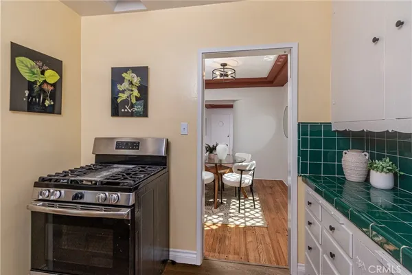 a kitchen with stainless steel appliances a stove a sink and a dining table