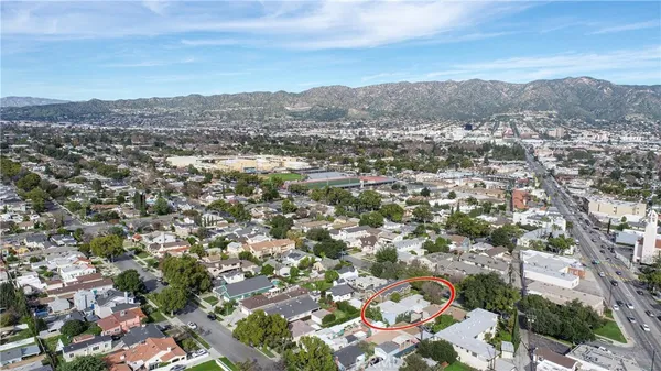 an aerial view of residential houses with outdoor space and trees