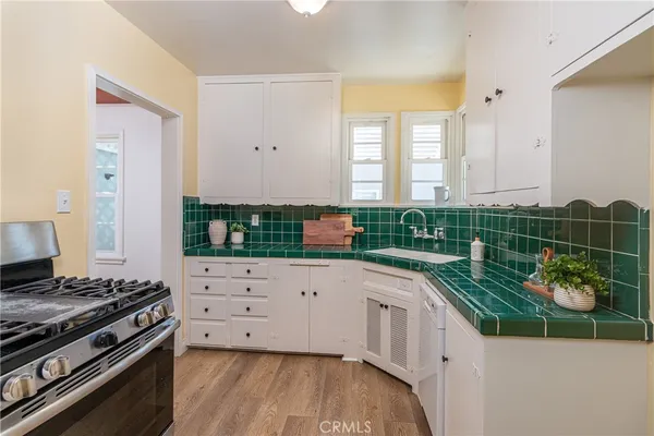 a kitchen with stainless steel appliances a stove and a wooden floor