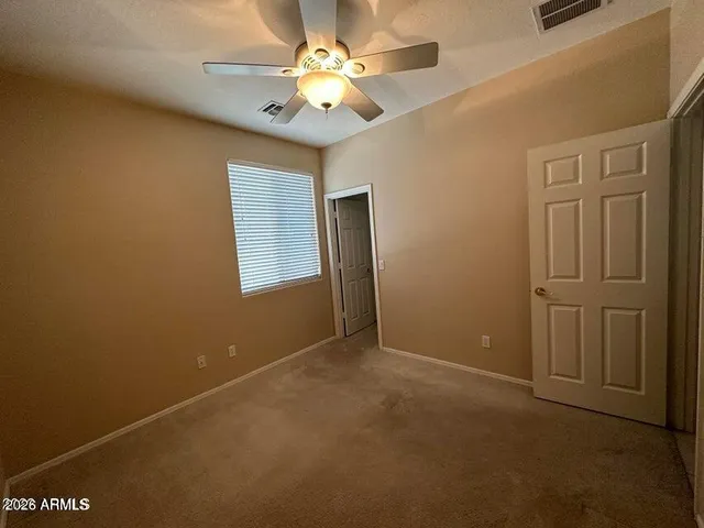 an empty room with windows and fan