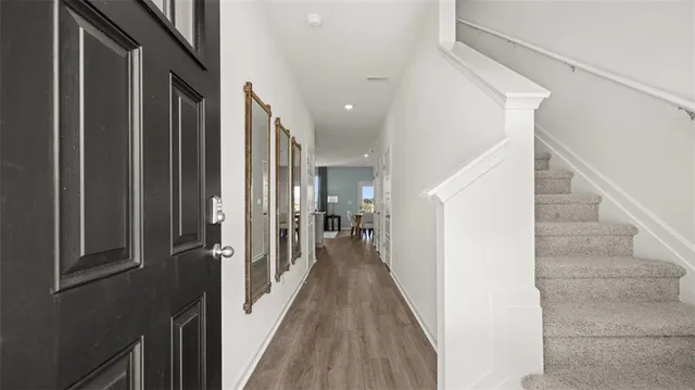 a view of a hallway with wooden floor and staircase