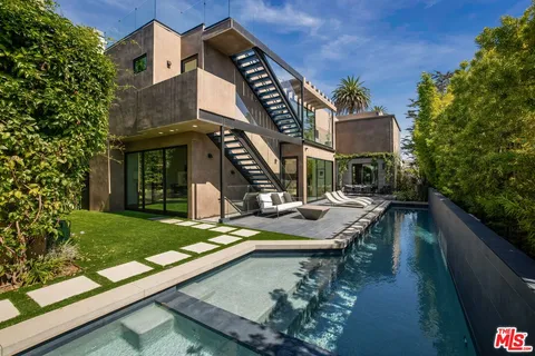 a view of a house with pool and chairs