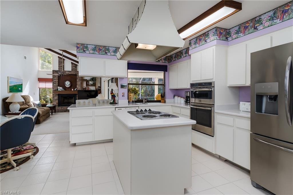 1502 Foxfire Lane Naples, FL 34104 - Photo 20 of 49 a kitchen with stainless steel appliances granite countertop a stove refrigerator sink and a microwave